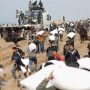 Sejumlah warga Palestina membawa sekarung tepung yang diambil dari truk bantuan di dekat pos pemeriksaan Israel, ketika menghadapi krisis kelaparan (foto: Reuters)