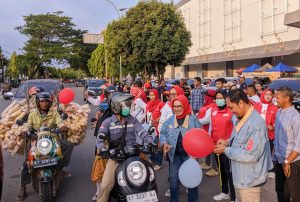 Rayakan Sumpah Pemuda, Najirah-Aswar bagi-bagi balon di simpang Ramayana Bontang (aset: galang/katakaltim)