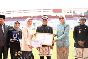 Sekda Provinsi Kalimantan Timur (Kaltim), Sri Wahyuni, menyerahkan penghargaan kepada sekda Bontang Aji Erlynawati pada momen perayaan HUT ke-25 Kota Bontang, di Stadion Taman Prestasi Kota Bontang, Sabtu (12/10/2024). (Aset: sandi/katakaltim)