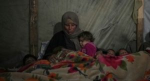 Seorang nenek membungkus cucuknya di tenda pengungsian di Jalur Gaza. (Dok: VOA)