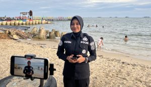 Satgas Humas dalam Operasi Lilin Mahakam 2024 Polda Kaltim memantau situasi di kawasan wisata pantai Kota Balikpapan. (Dok: hilman/katakaltim.com)