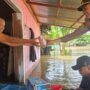 Kapolsek Muara Wahau, AKP Satria Yudha, memberikan bantuan makanan bagi korban banjir di Desa Nehas Liah Bing. (dok: ainun/katakaltim)