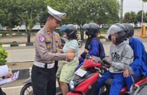 Kasat Lantas Polres Kukar, Iptu Ahmad Fandoli saat membagikan brosur kepada pengendara. (dok: Akbar/katakaltim)