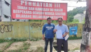 Kuasa hukum warga, Mardiansyah, dan salah seorang warga Heny saat berada di lokasi eks Hotel Tirta yang berada di Jalan Jenderal Ahmad Yani, Nomor 8, Kelurahan Mekarsari, Balikpapan Tengah setelah memasang spanduk untuk larangan melakukan segala bentuk kegiatan di lokasi tersebut karena masih dalam perkara, Selasa (6/5/2025). (Dok: hlm/katakaltim)