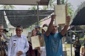 Bupati Kutim Ardiansyah Sulaiman saat menyerahkan sertifikat tanah hak milik di Dusun Sidrap, Desa Martadinata, Kecamatan Teluk Pandan, Rabu 18 Juni 2025 (dok: agu/katakaltim)