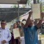 Bupati Kutim Ardiansyah Sulaiman saat menyerahkan sertifikat tanah hak milik di Dusun Sidrap, Desa Martadinata, Kecamatan Teluk Pandan, Rabu 18 Juni 2025 (dok: agu/katakaltim)